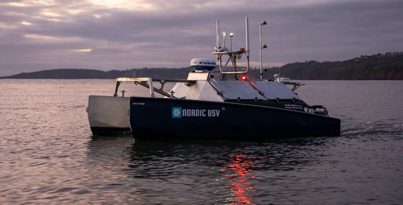 USV Storm på rolig sjø i solnedgang.